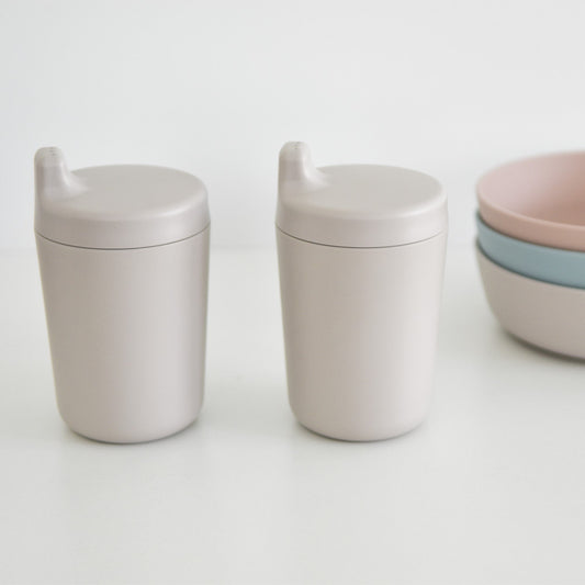 two plant based children's sippy cups side by side with a set of bowls in the background
