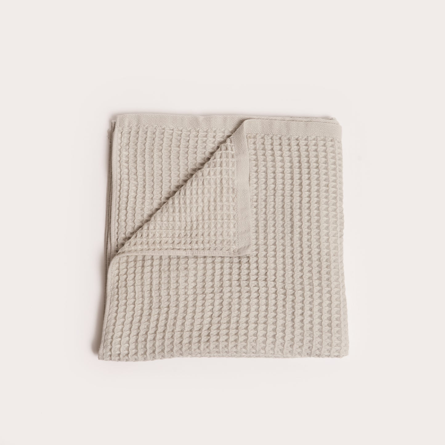 dove light grey folded organic cotton waffle towel with one corner folded down