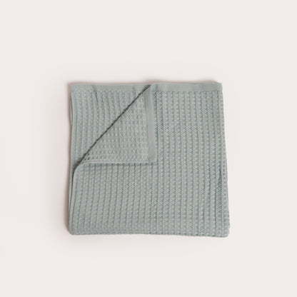 seafoam blue green coloured folded organic cotton waffle towel with one corner folded down
